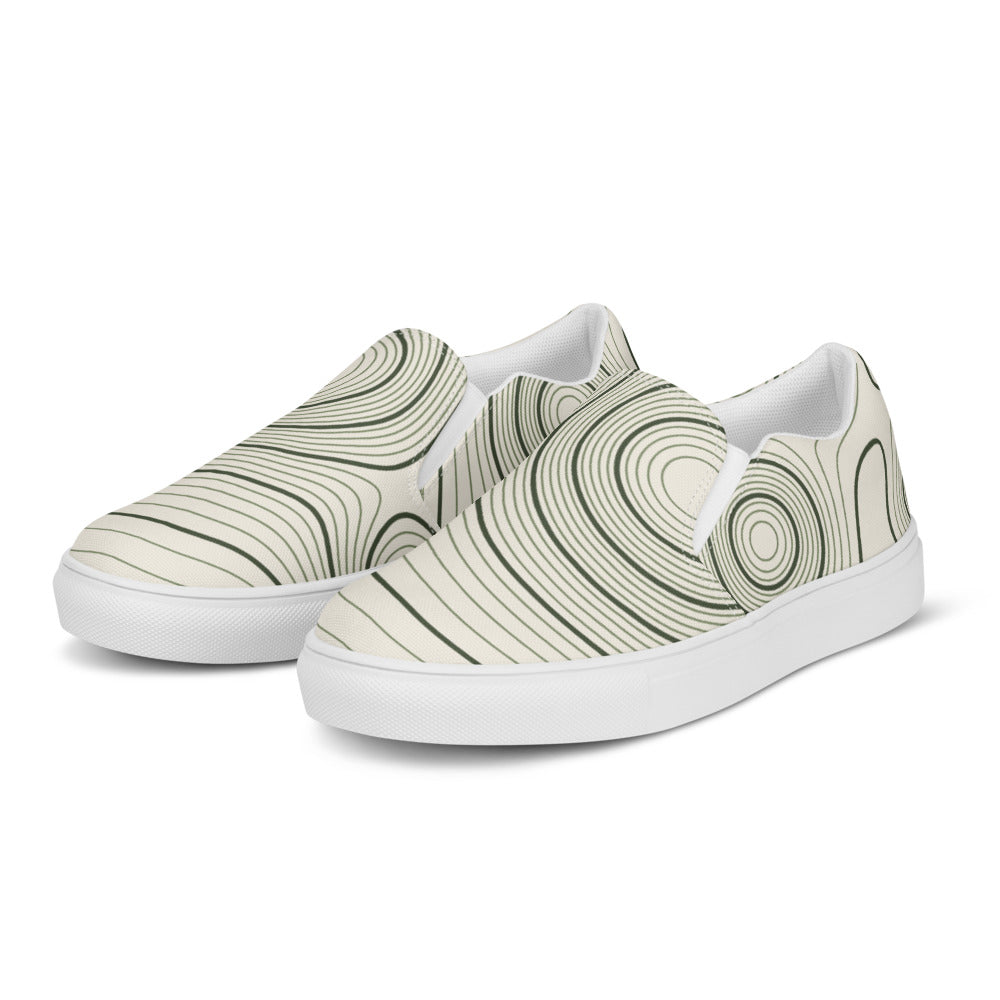 Zapatillas slip-on de hombre con patrón topográfico oliva sobre crema, vista angular