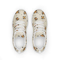 Zapatillas deportivas de mujer con rosetas de pantera caramelo y carbón sobre arena, con coronas doradas escondidas